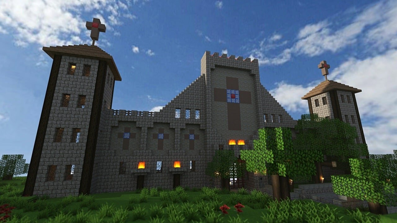 A large stone castle build in Minecraft with lit windows at dusk