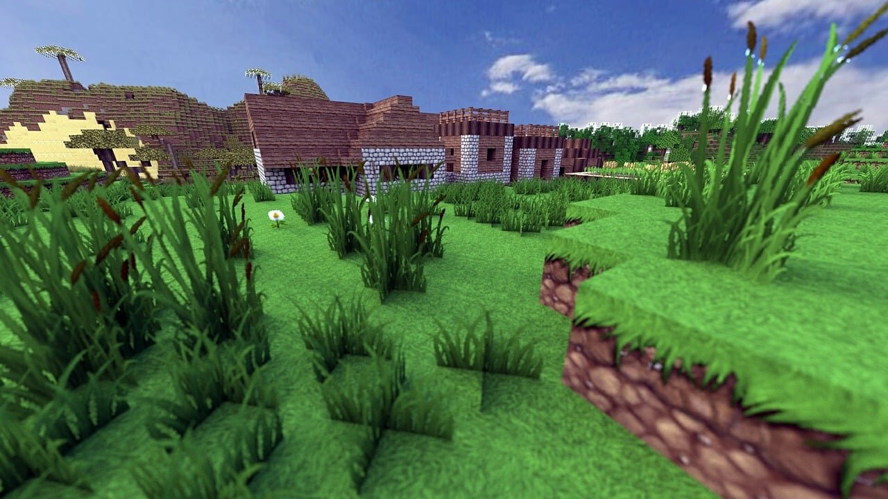 A stone and wood Minecraft build surrounded by tall grass